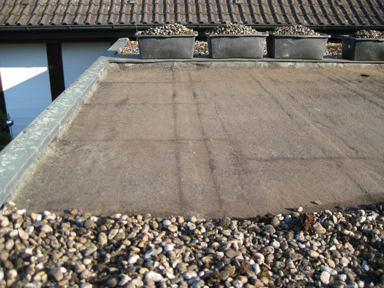 Ein undichtes Dach einer Doppelgarage soll abgedichtet werden. Der Kies wurde bereits abgeräumt